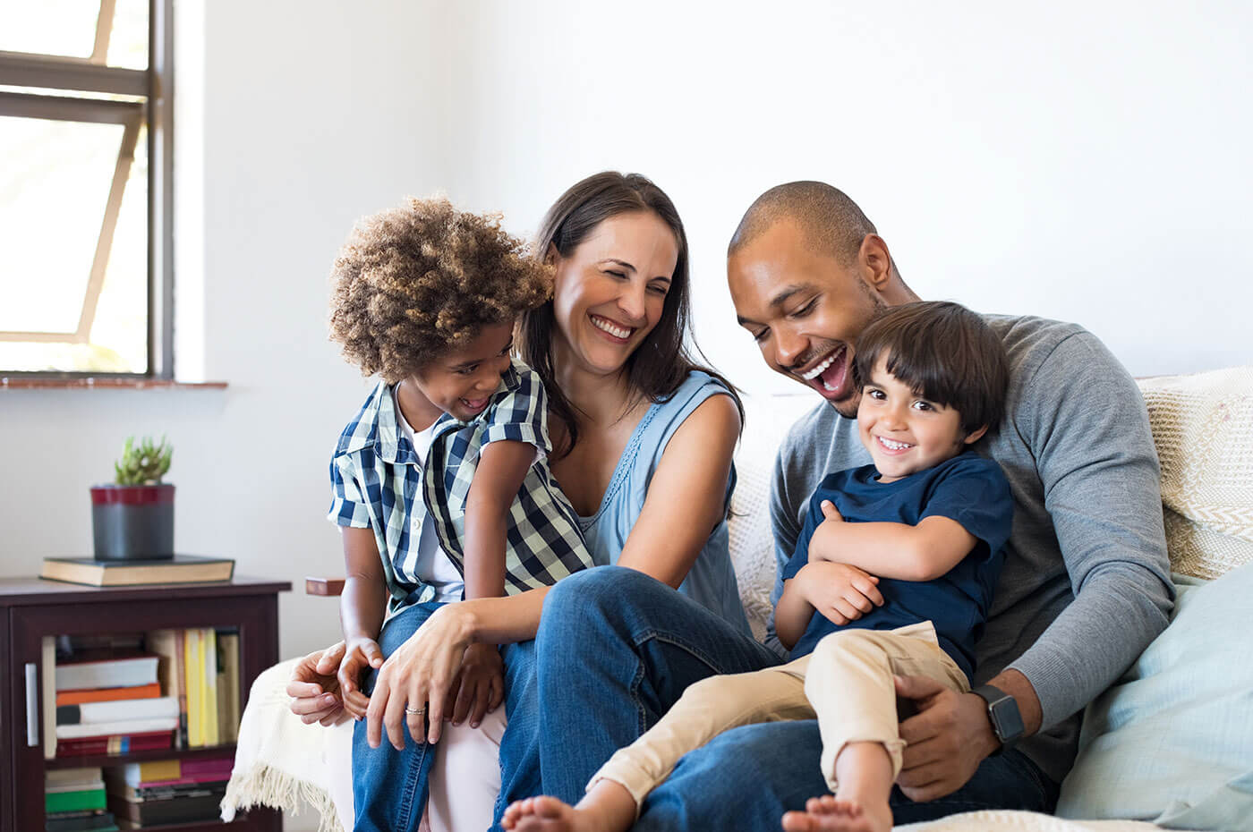 Family sitting together on couch with big smiles